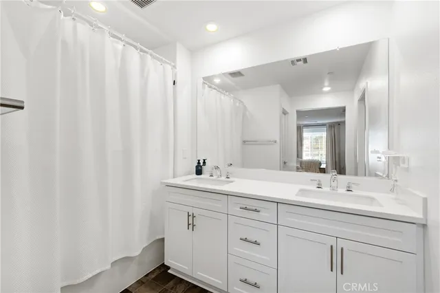 a bathroom with a double vanity sink and mirror