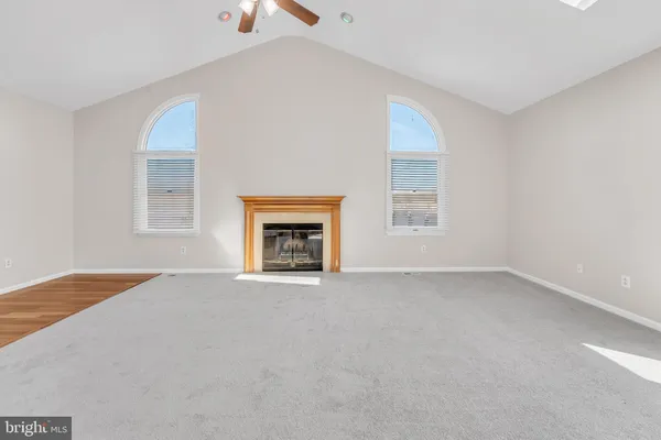 a large white kitchen with a sink window and stainless steel appliances