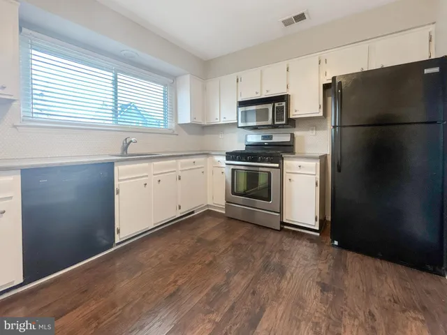 a kitchen with stainless steel appliances granite countertop a refrigerator sink and microwave
