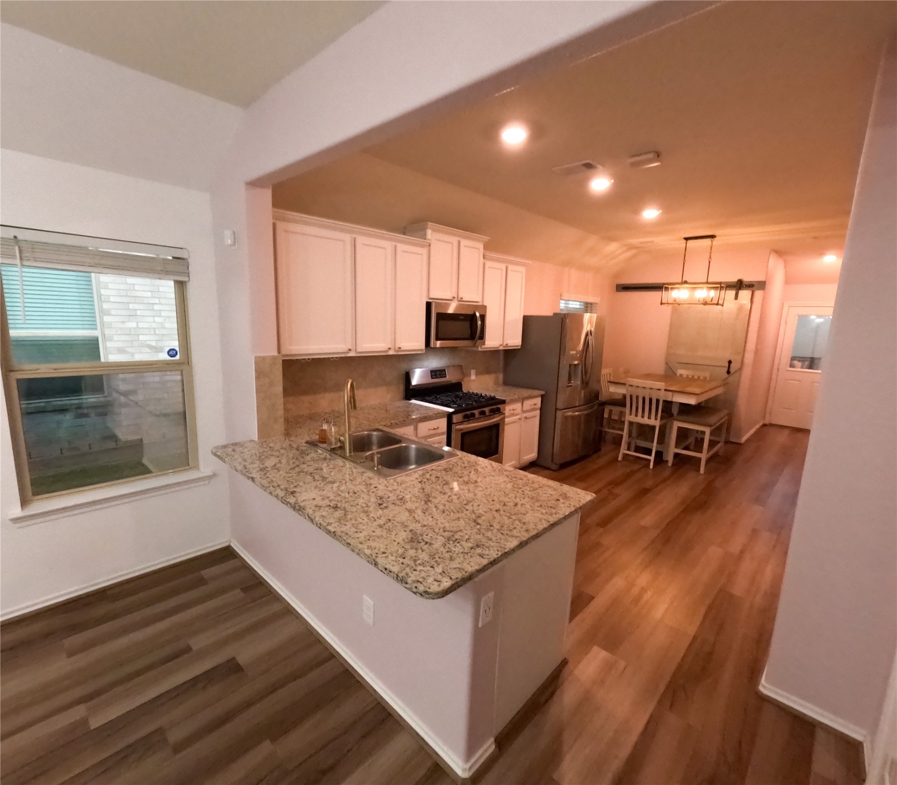 5515 Savanna Pasture Road Katy, TX 77493 - Photo 7 of 17 a kitchen with stainless steel appliances granite countertop a sink stove and wooden floor