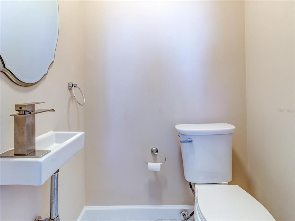 518 Riverside Drive Tarpon Springs, FL 34689 - Photo 32 of 82 a white toilet sitting next to a bathroom sink