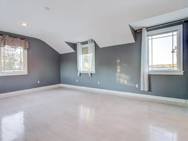 a view of a large room with wooden floor and windows