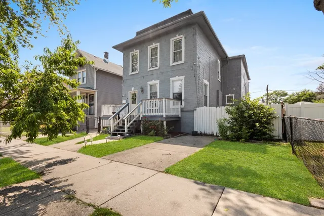 a front view of a house with a yard and trees