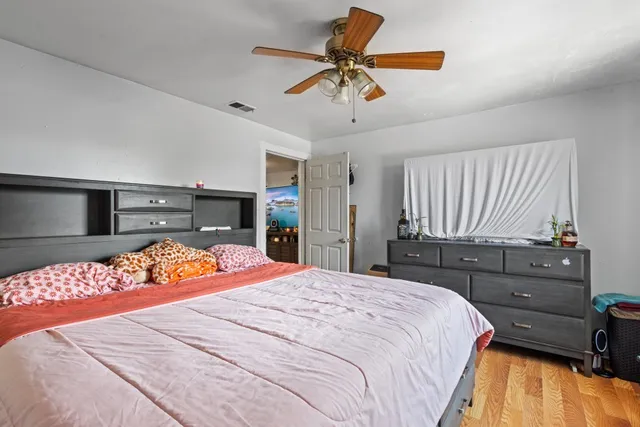 a bedroom with a bed and wooden floor