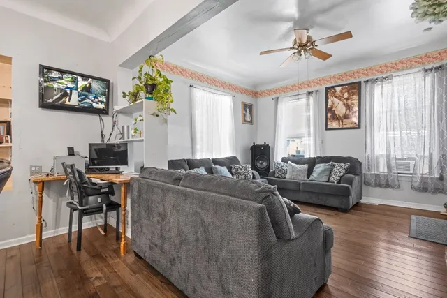 a living room with furniture and a wooden floor