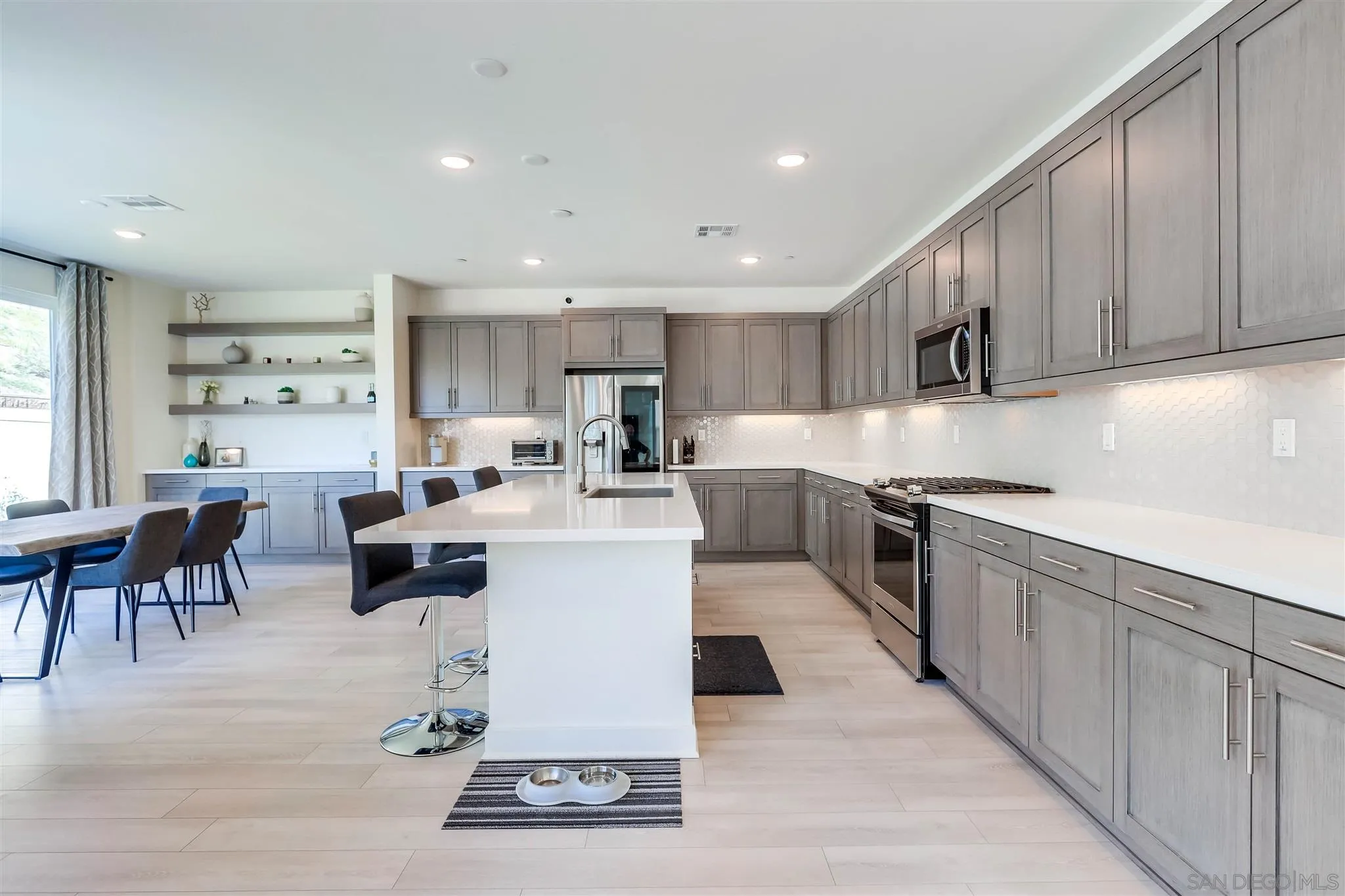8922 Trailridge Avenue Santee, CA 92071 - Photo 8 of 31 a kitchen with stainless steel appliances kitchen island granite countertop a sink a stove a refrigerator cabinets and chairs
