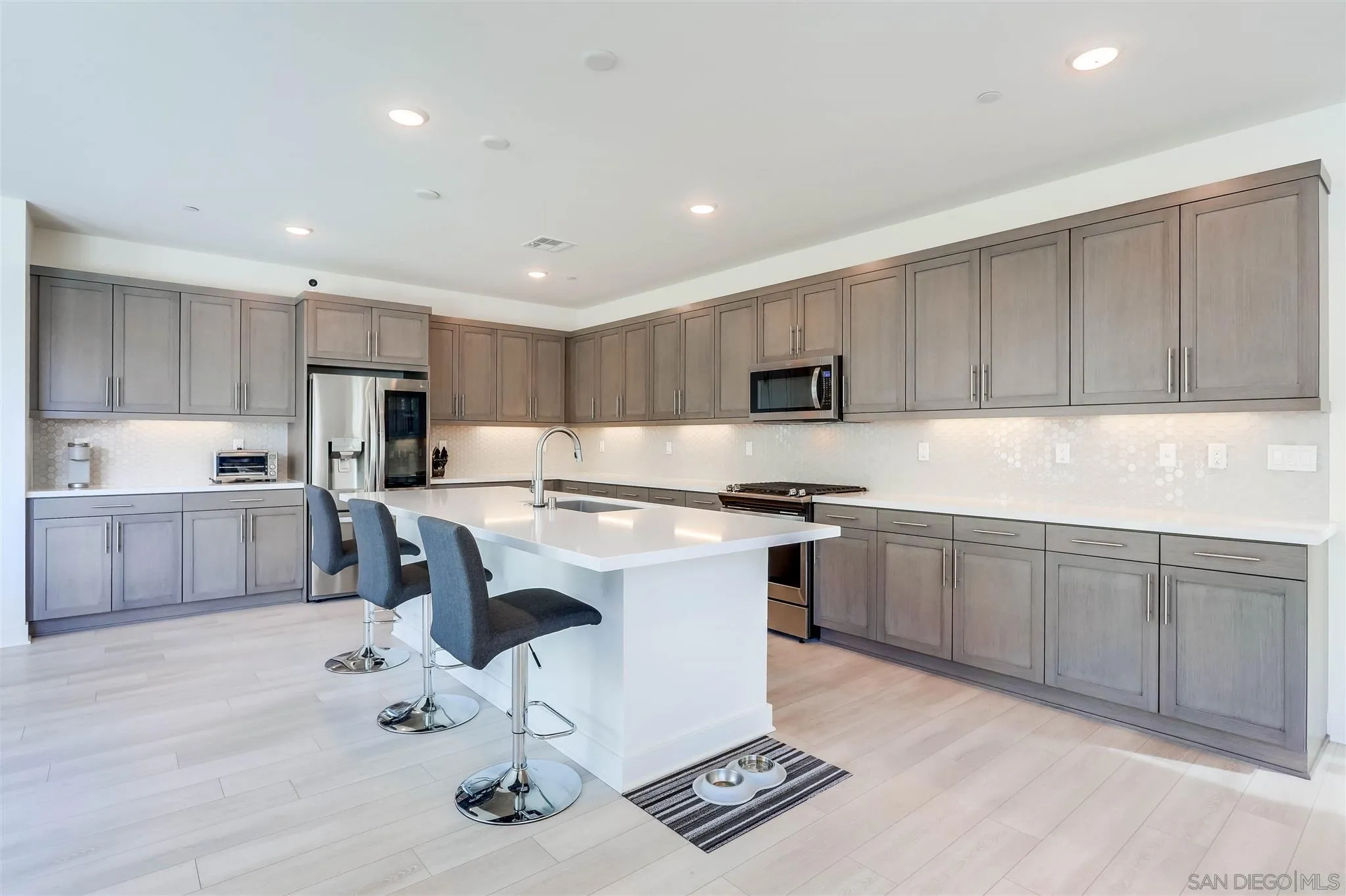 8922 Trailridge Avenue Santee, CA 92071 - Photo 9 of 31 a kitchen with a sink a counter top space stainless steel appliances and cabinets