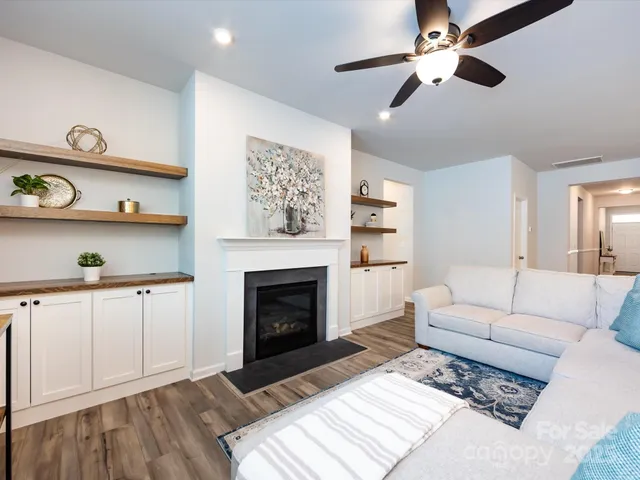 a living room with furniture kitchen view and a chandelier
