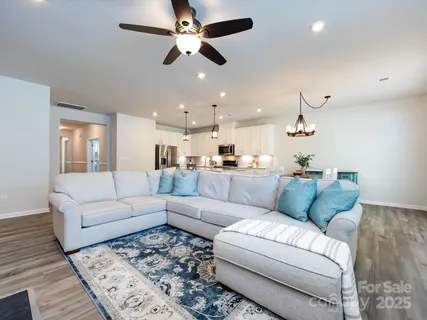 a kitchen with stainless steel appliances granite countertop a dining table chairs refrigerator and microwave