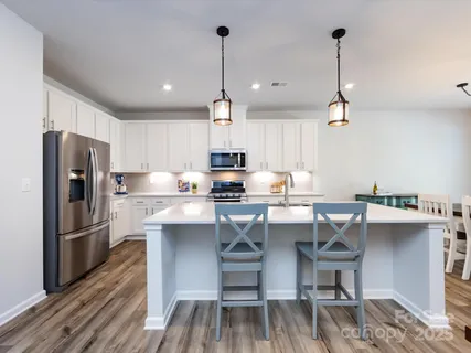 a kitchen with kitchen island granite countertop a sink table and chairs