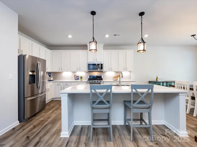 a kitchen with kitchen island granite countertop a sink table and chairs