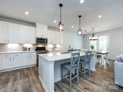 a kitchen with granite countertop white cabinets and stainless steel appliances