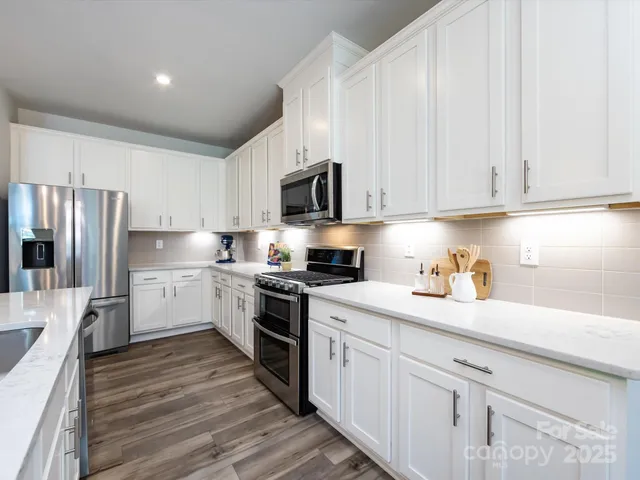 a kitchen with white cabinets and white appliances