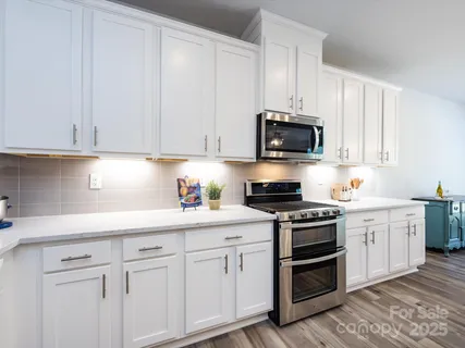 a kitchen with stainless steel appliances granite countertop a stove a sink and a microwave