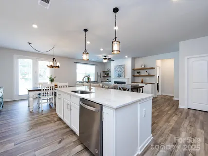 a kitchen with stainless steel appliances granite countertop a sink a stove and a refrigerator