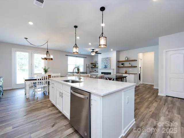 a kitchen with stainless steel appliances granite countertop a sink a stove and a refrigerator