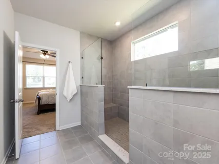 a spacious bathroom with a granite countertop sink a mirror and a shower