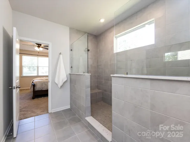a spacious bathroom with a granite countertop sink a mirror and a shower