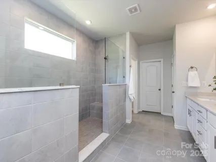 a spacious bathroom with a granite countertop sink two mirror and a