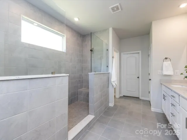 a spacious bathroom with a granite countertop sink two mirror and a