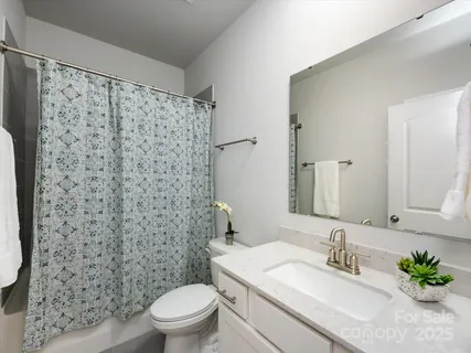 a spacious bedroom with a bed and a chandelier