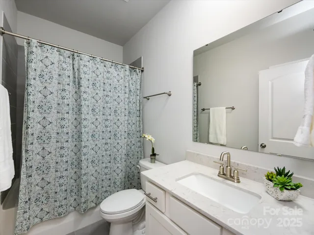 a spacious bedroom with a bed and a chandelier