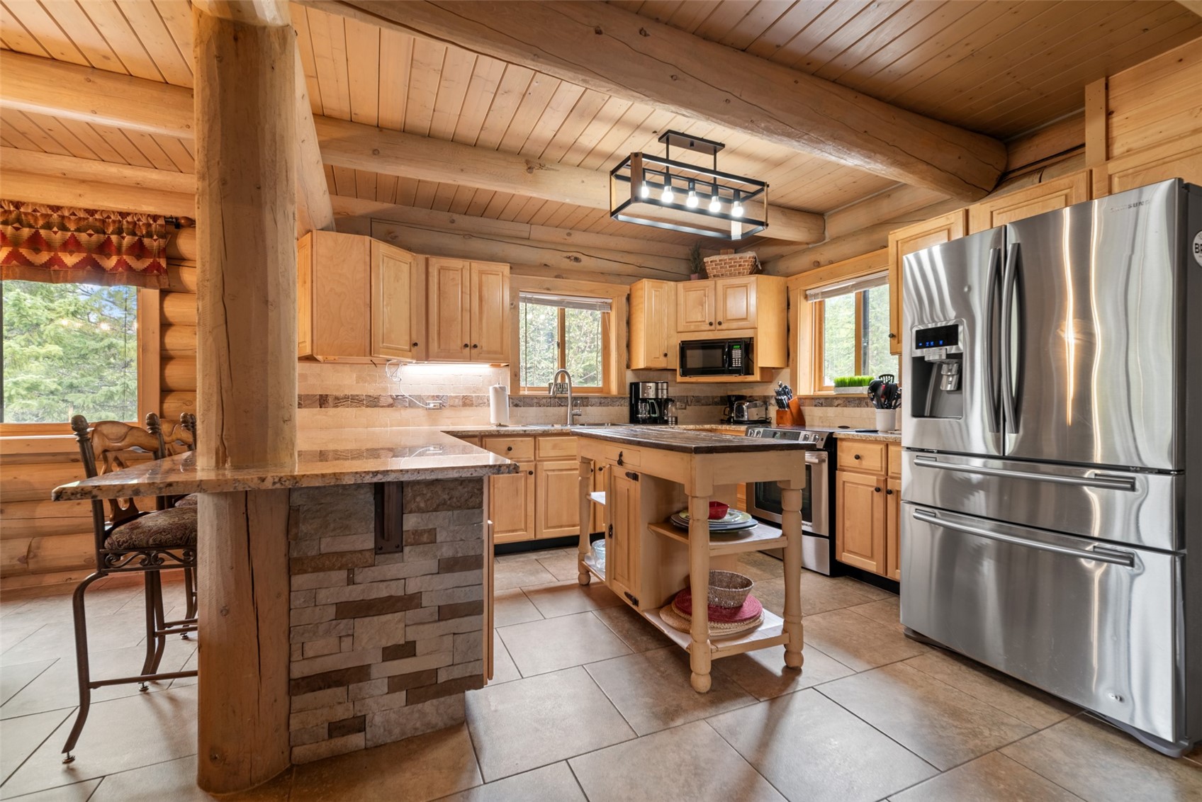 243 Rena Road Breckenridge, CO 80424 - Photo 24 of 50 Kitchen featuring appliances with stainless steel finishes, wooden ceiling, plenty of natural light, and log walls