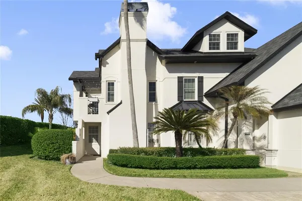 a front view of a house with a yard and potted plants
