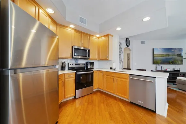 a kitchen with stainless steel appliances a refrigerator and a stove top oven