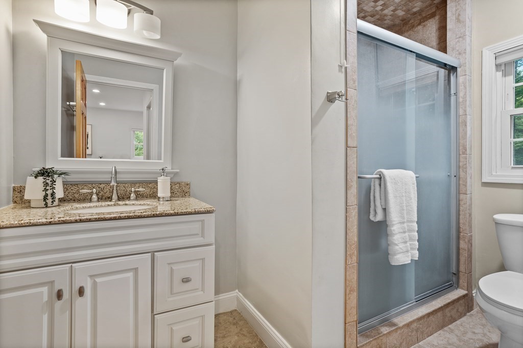 26 Alta Road Sudbury, MA 01776 - Photo 15 of 37 a bathroom with a granite countertop sink a toilet and a mirror
