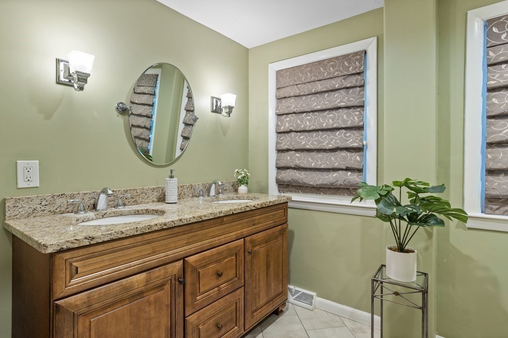 26 Alta Road Sudbury, MA 01776 - Photo 17 of 37 a bathroom with a granite countertop sink a potted plant and a mirror