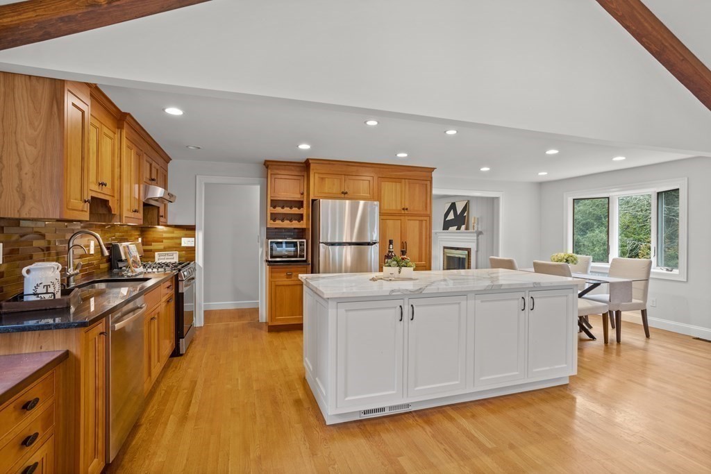 26 Alta Road Sudbury, MA 01776 - Photo 6 of 37 a large kitchen with stainless steel appliances a large counter top a stove a chimney a sink and a refrigerator