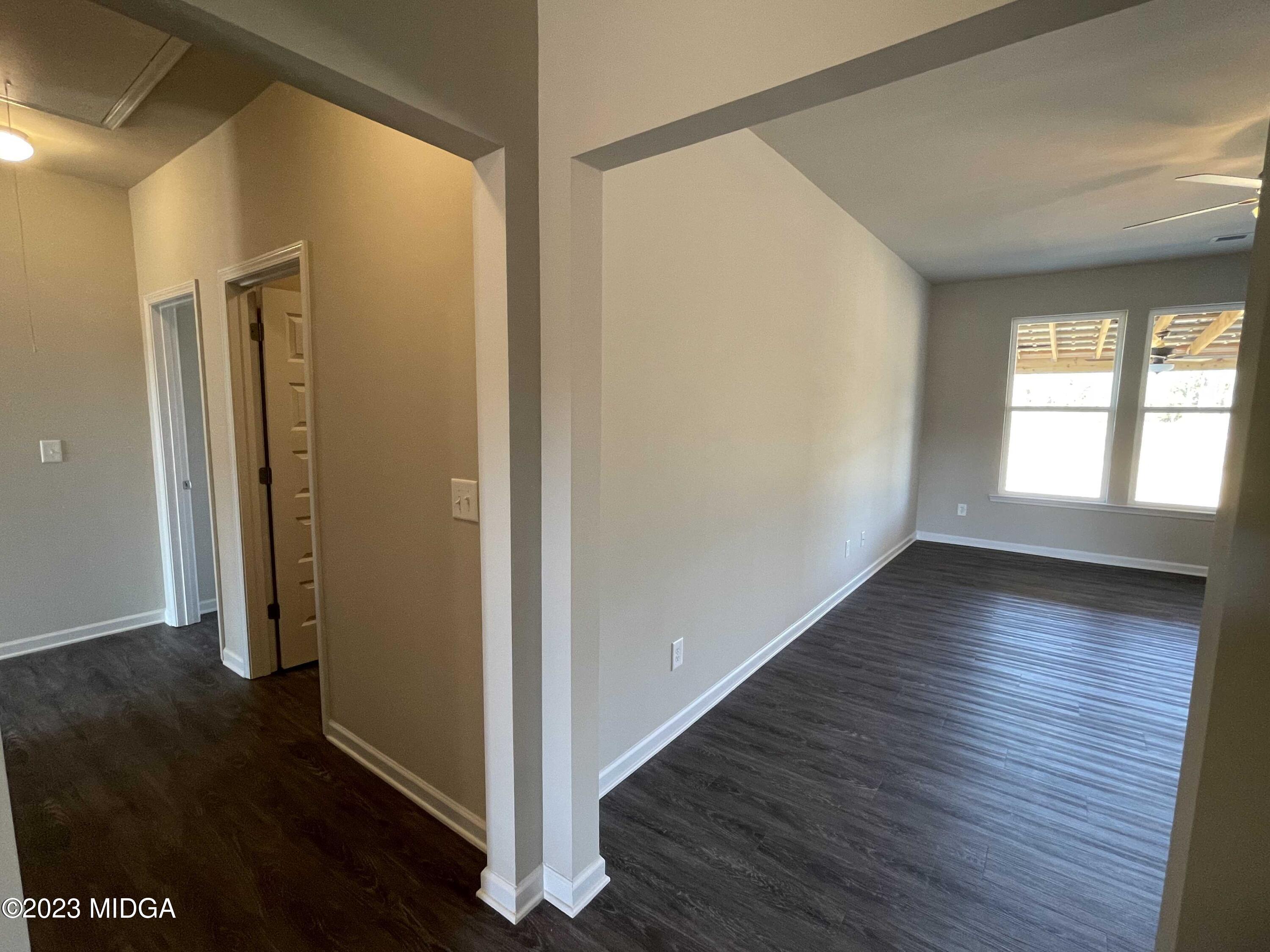 159 Sanders Road Macon, GA 31210 - Photo 11 of 40 a view of an empty room with wooden floor and a window