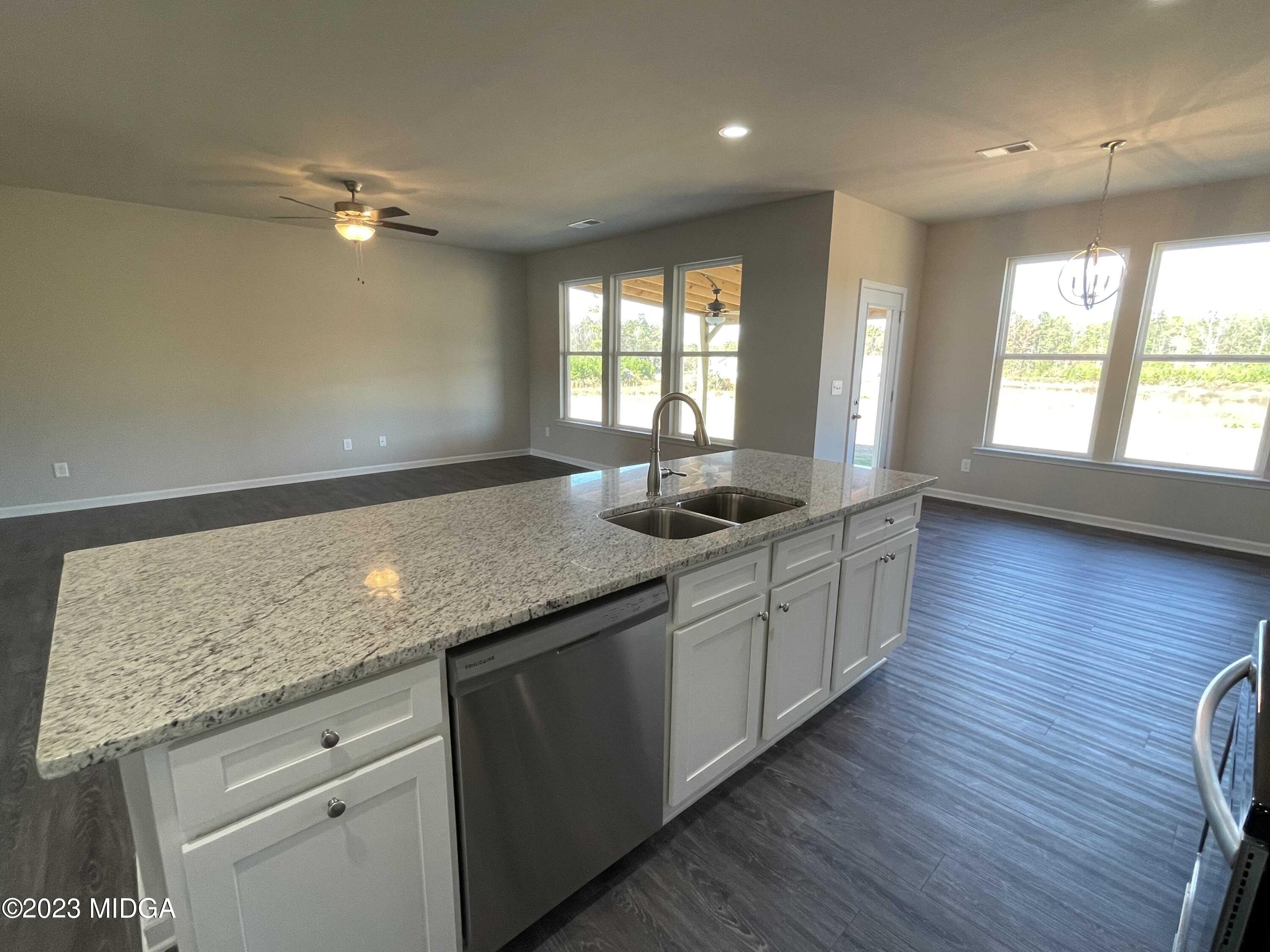 159 Sanders Road Macon, GA 31210 - Photo 16 of 40 a kitchen with granite countertop wooden floors and wide window