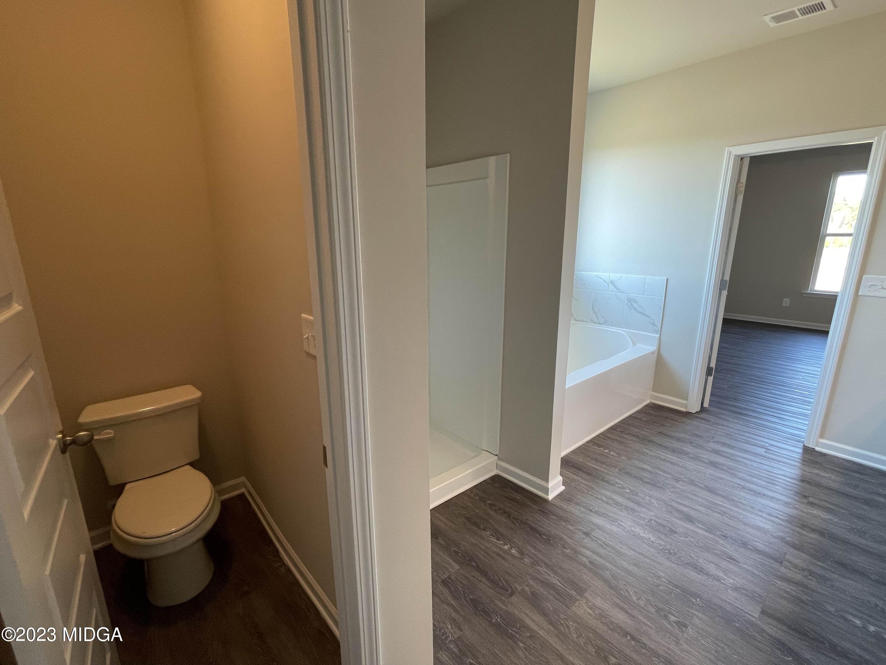 159 Sanders Road Macon, GA 31210 - Photo 27 of 40 a bathroom with a toilet and a wooden floor