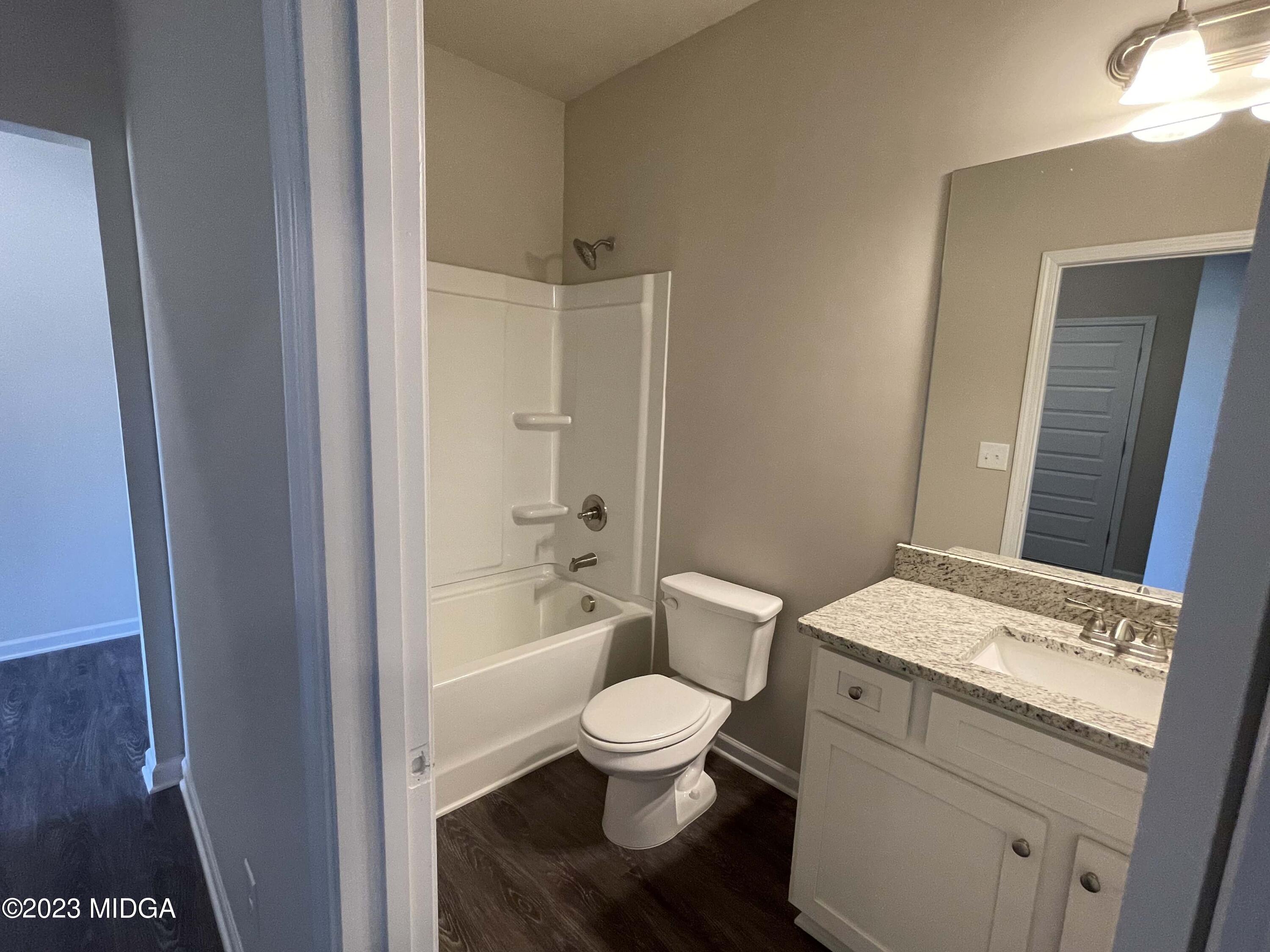 159 Sanders Road Macon, GA 31210 - Photo 7 of 40 a bathroom with a granite countertop toilet a sink and a mirror