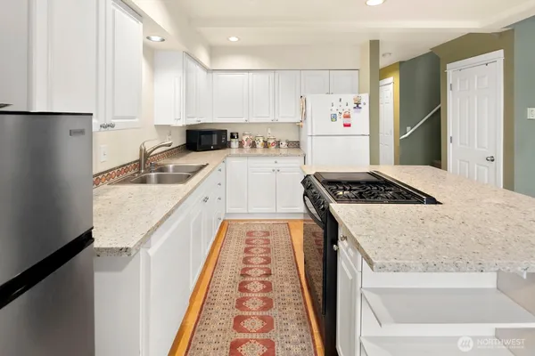 a kitchen with stainless steel appliances granite countertop a refrigerator and a stove