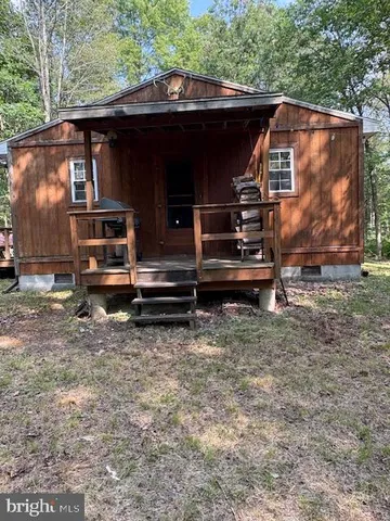a view of house with backyard space and deck