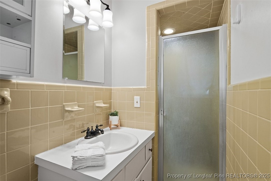 2434 North Bragg Boulevard Spring Lake, NC 28390 - Photo 27 of 44 a bathroom with a sink a mirror and a shower