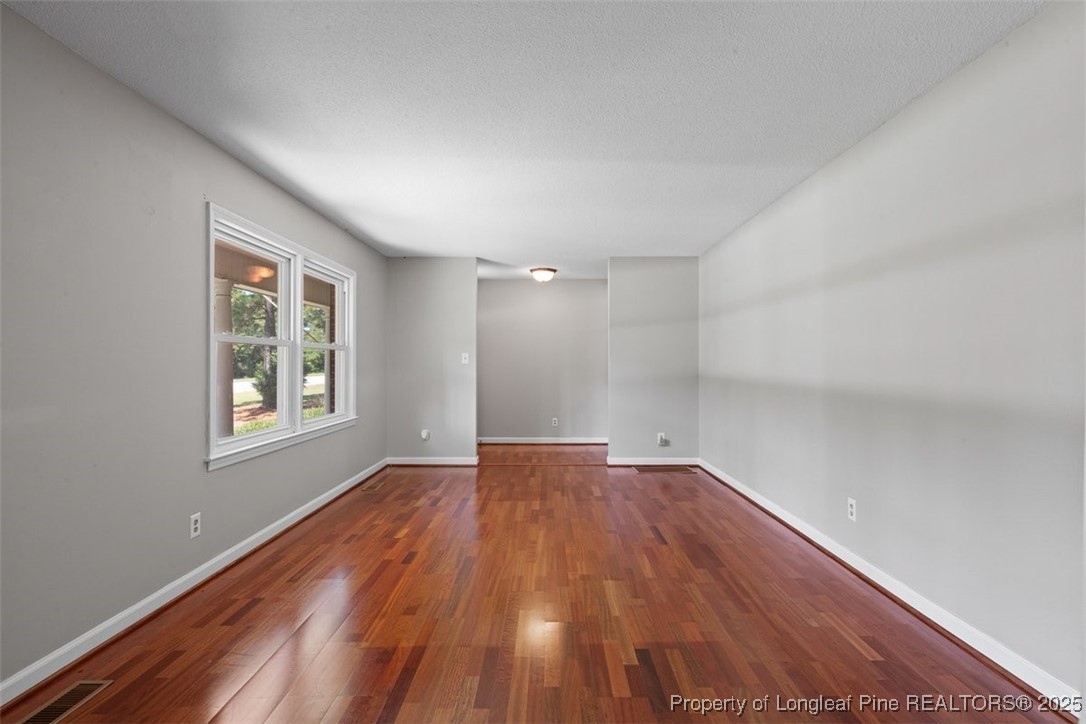 2434 North Bragg Boulevard Spring Lake, NC 28390 - Photo 7 of 44 a view of an empty room with wooden floor and a window