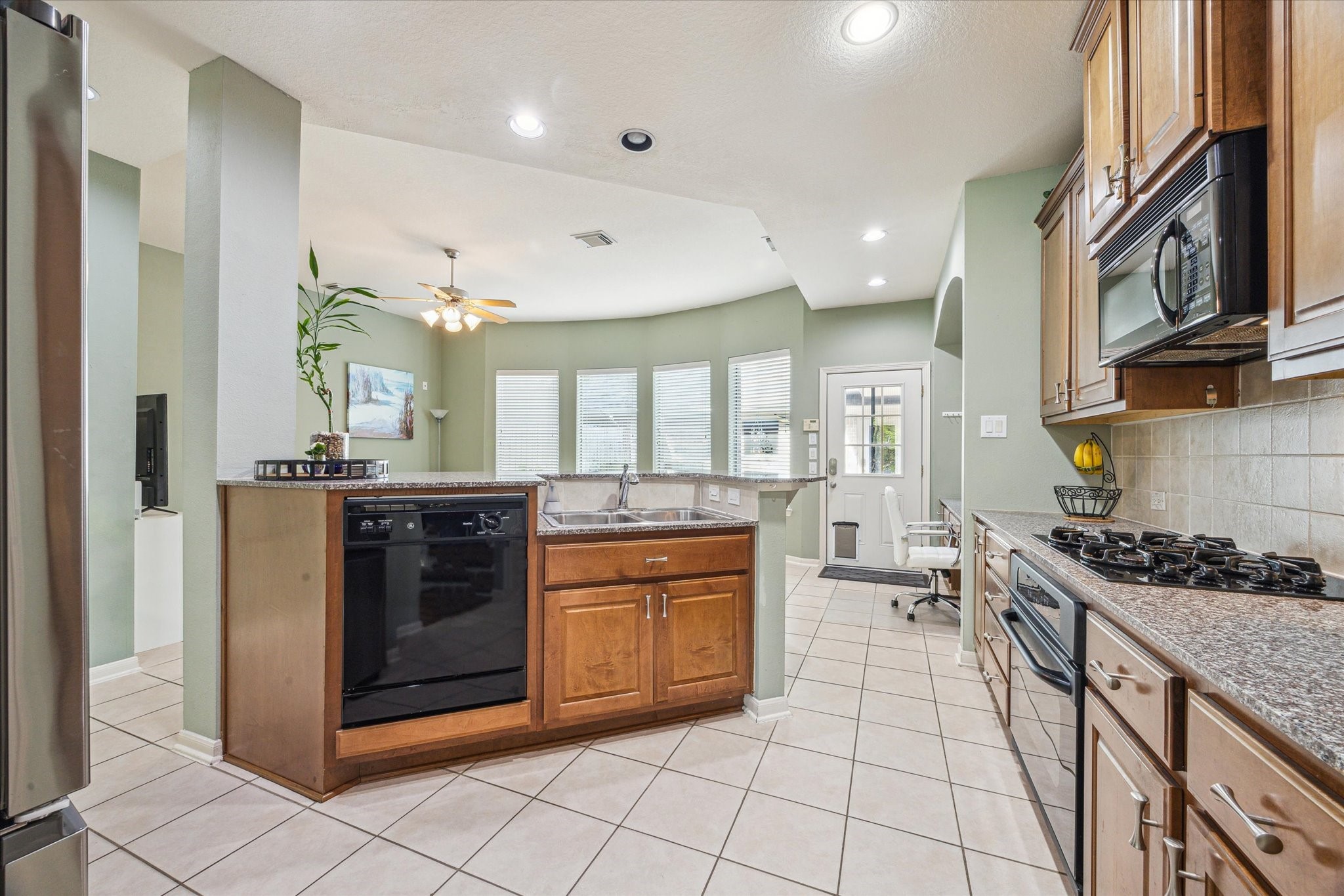 2403 Clippers Square Houston, TX 77058 - Photo 11 of 20 a kitchen with stainless steel appliances granite countertop a stove a sink and a microwave
