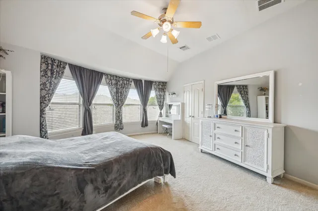 a spacious bedroom with a large bed and a dresser