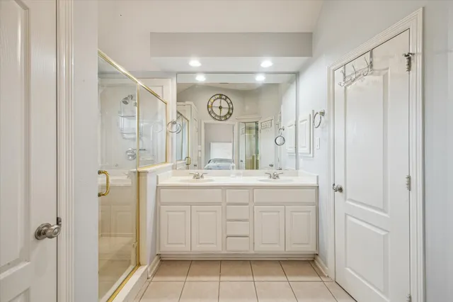 a bathroom with a double vanity sink mirror and shower