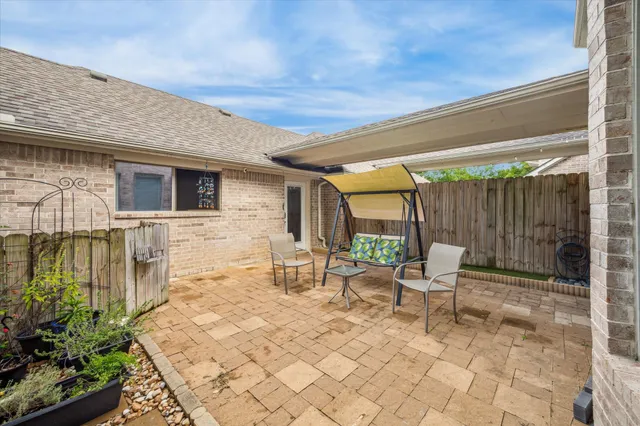 a view of a patio with a table and chairs and potted plants