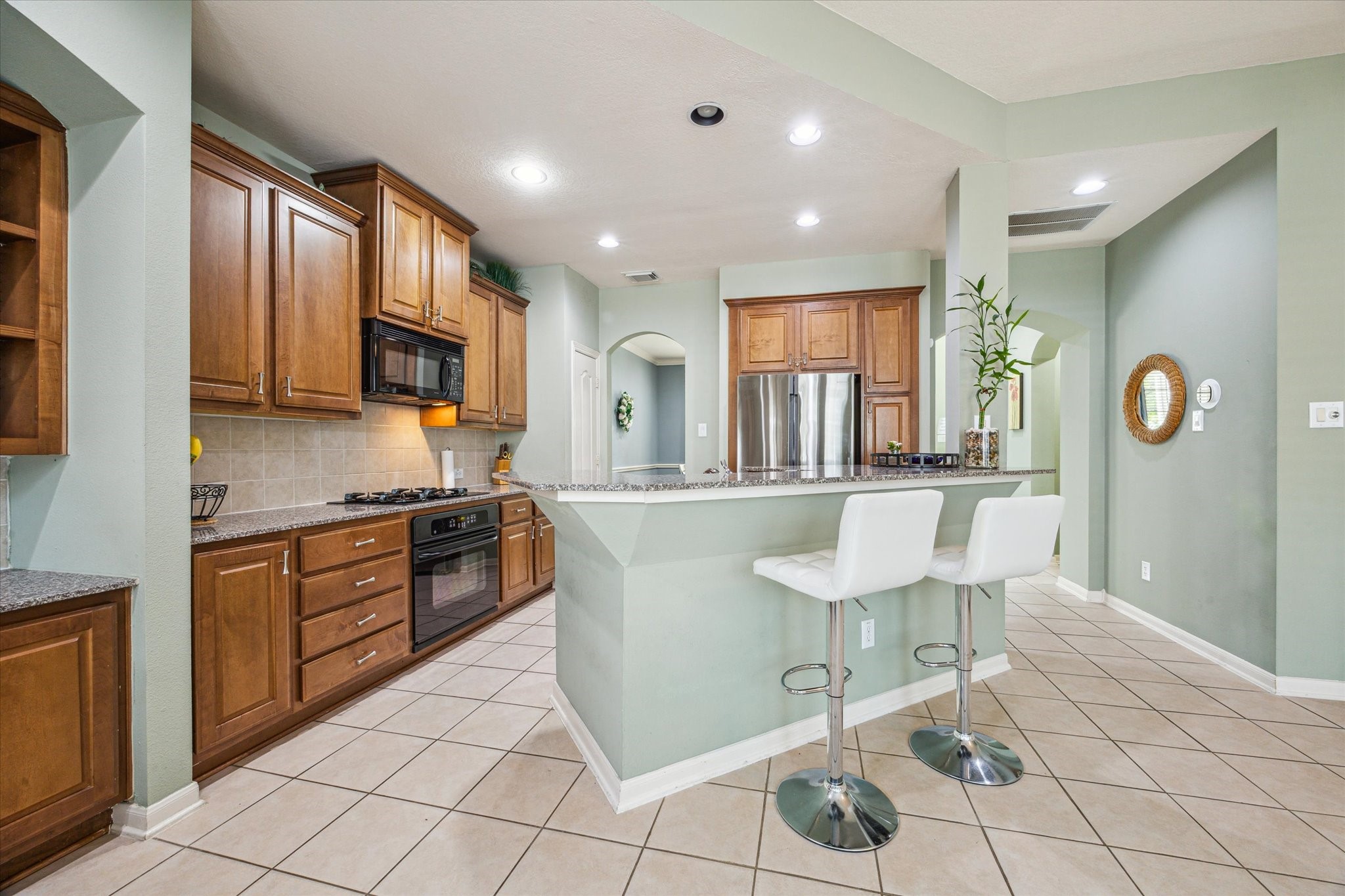 2403 Clippers Square Houston, TX 77058 - Photo 9 of 20 a large kitchen with stainless steel appliances granite countertop a stove a sink a dining table and chair