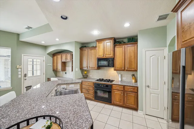 a large kitchen with stainless steel appliances granite countertop a stove and a sink