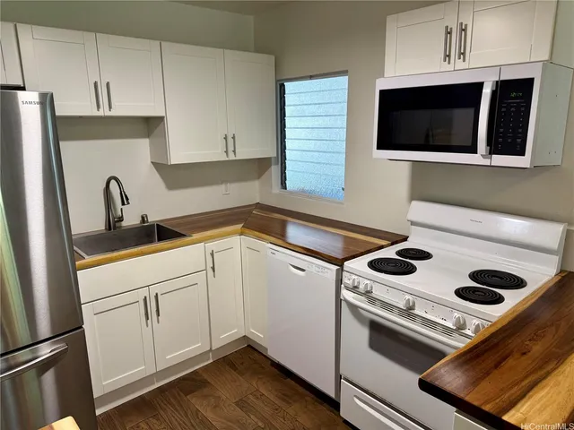 a kitchen with white cabinets and white appliances