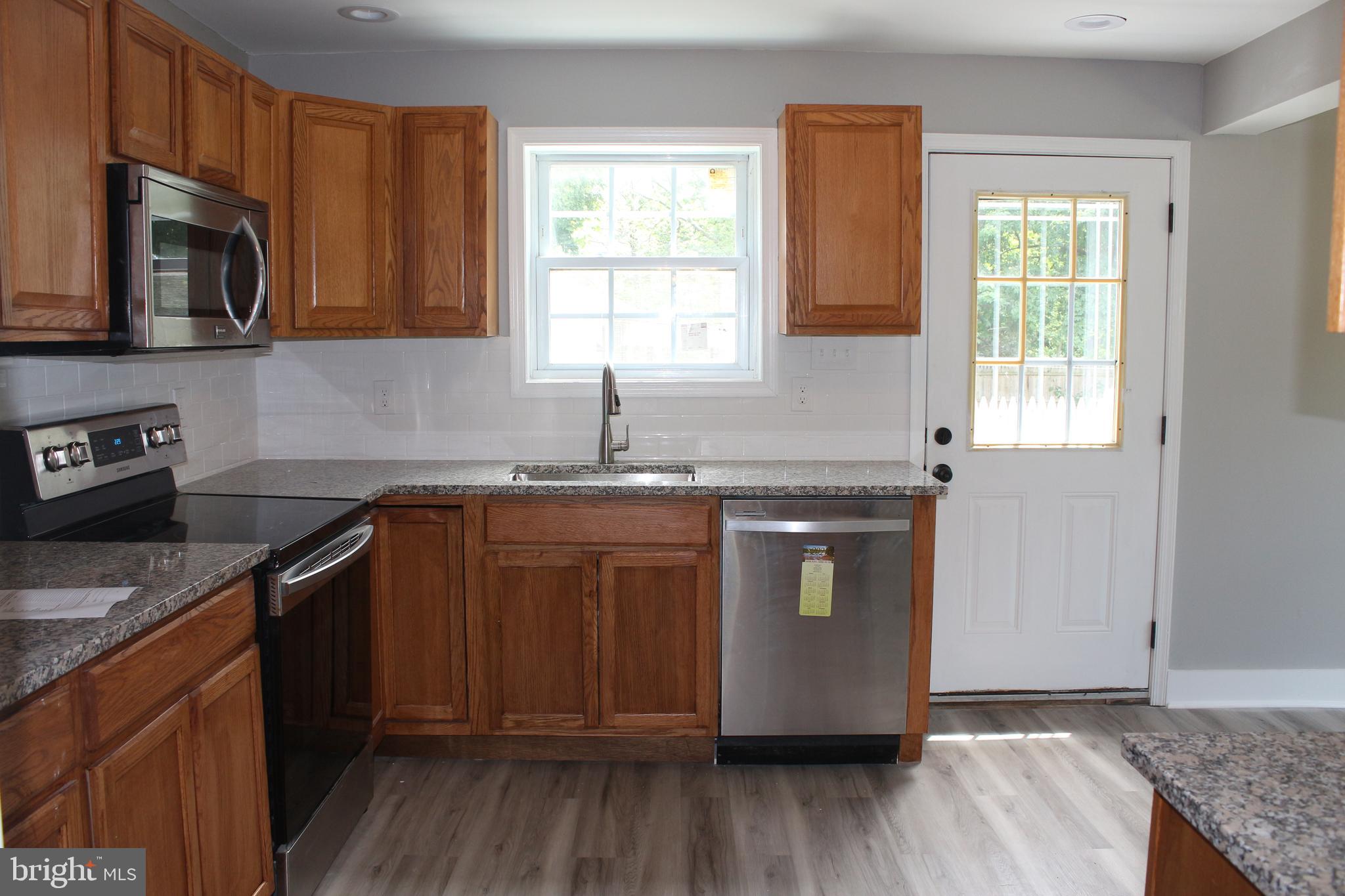 25 Church Street Glassboro, NJ 08028 - Photo 11 of 21 a kitchen with granite countertop wooden cabinets stainless steel appliances a window and a sink