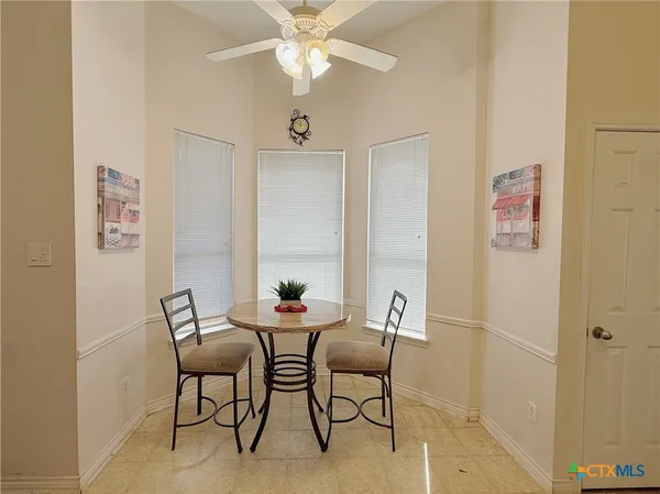 a view of a dining room with furniture and a chandelier fan
