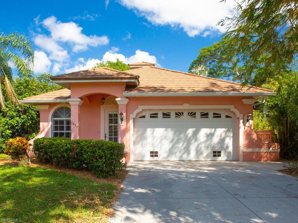 1079 Michigan Avenue Naples, FL 34103 - Photo 1 of 31 a front view of a house with a yard and garage